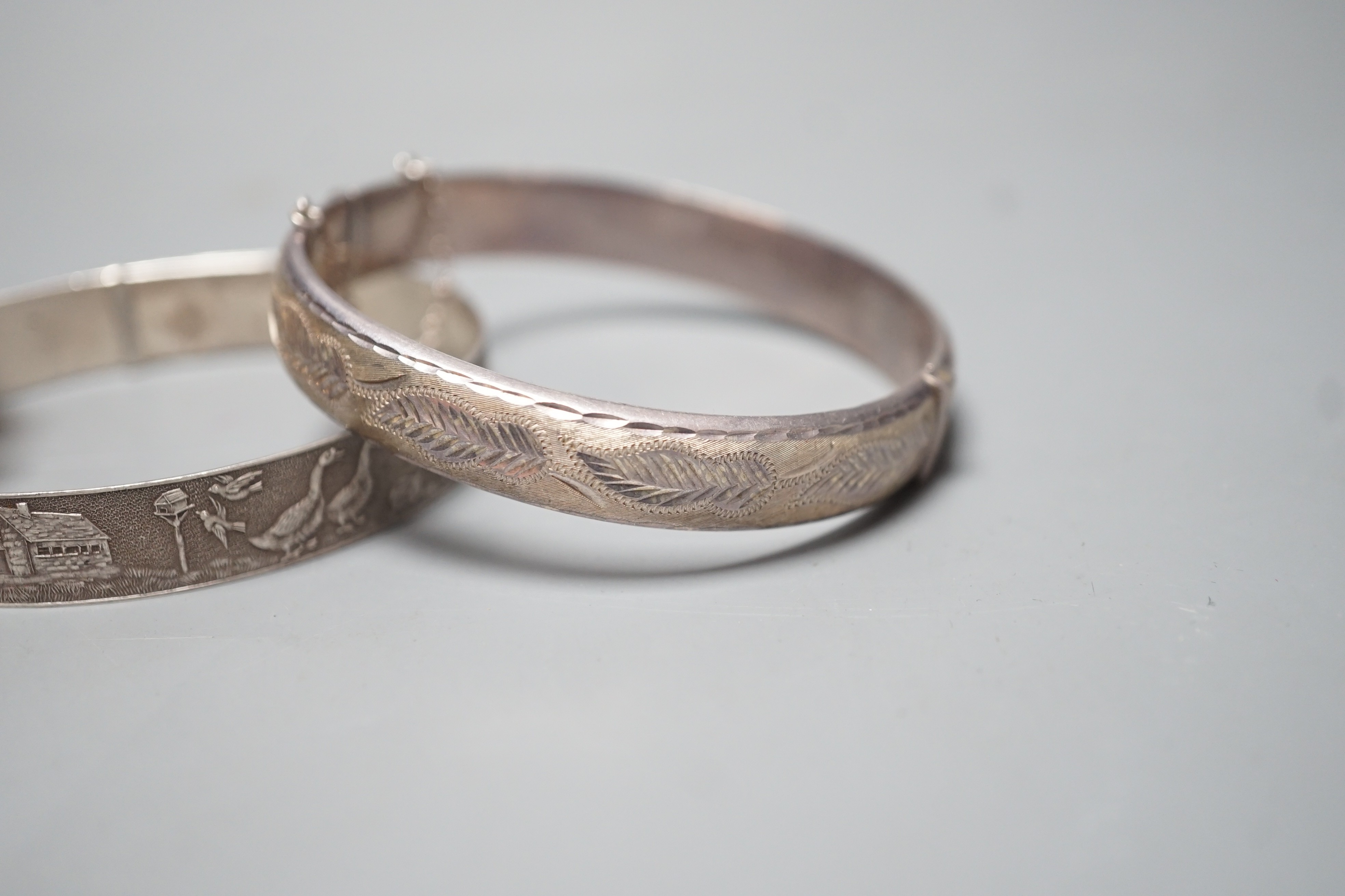 A modern 9ct gold and illusion set three stone diamond ring, size N/O, a Chinese gilt metal and mother of pearl bracelet and two white metal bangles, one hallmarked silver.